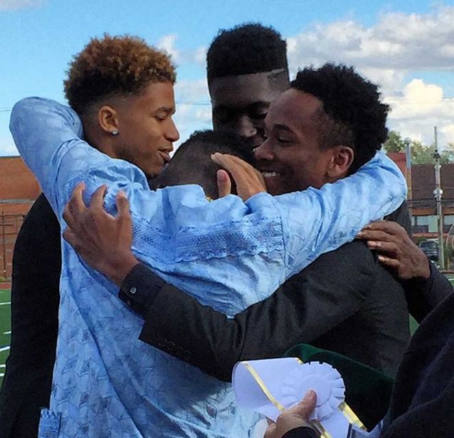 The Elmont Memorial High School 2015 Homecoming Court embraces Joseph Olawoye (blue shirt) after he is declared the 2015 Homecoming King. (Photo by Heather Doyle for Newsday, Oct. 17, 2015)